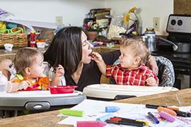 Baby feeds his mother cereal at breakfast